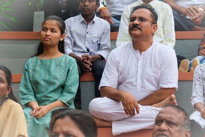 Sayaji Shinde sitting alongside event organizers and guests during indoor session